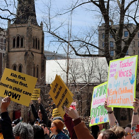 Advocates rally with signs to support increased funding for early childhood education and child care.