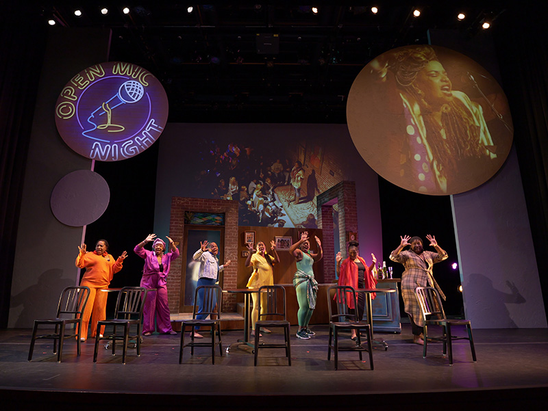 Performers on stage during an open mic night show.